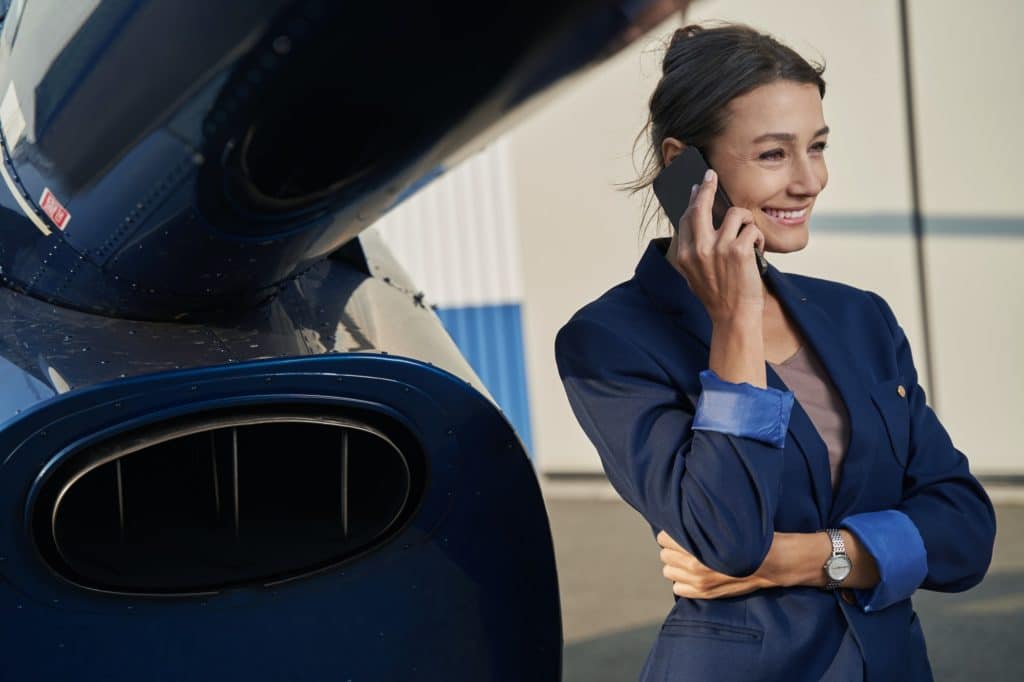 Joyful business lady talking on smartphone outdoors